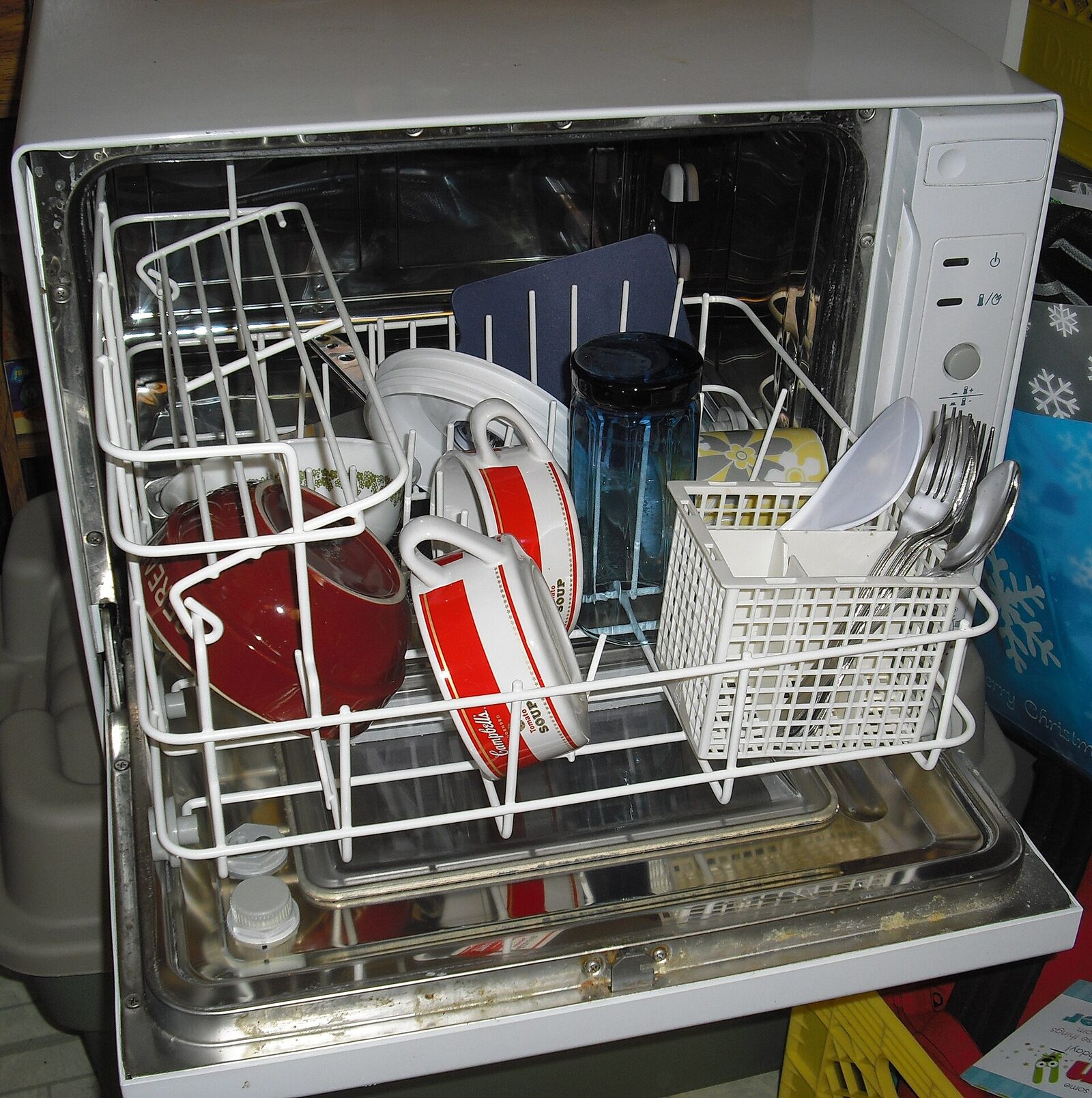 Loaded dishwasher with the door open in a kitchen