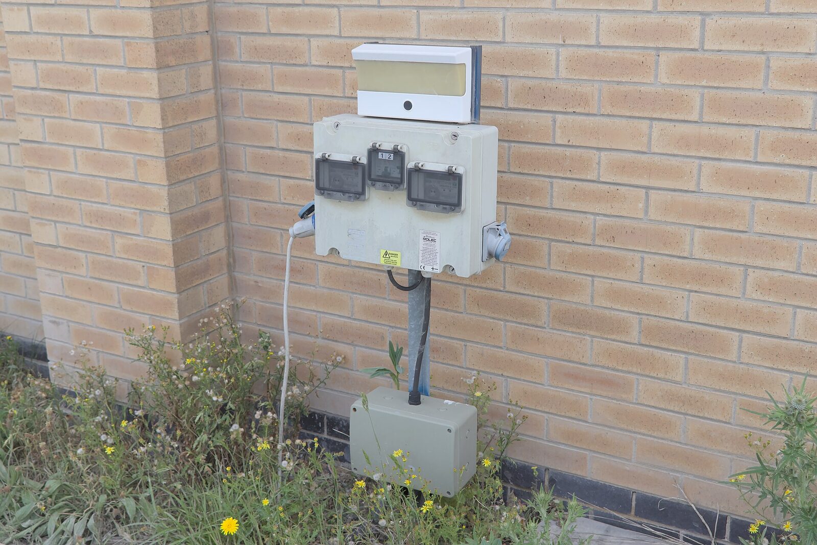 Electricity meter box mounted on the outside wall of a house