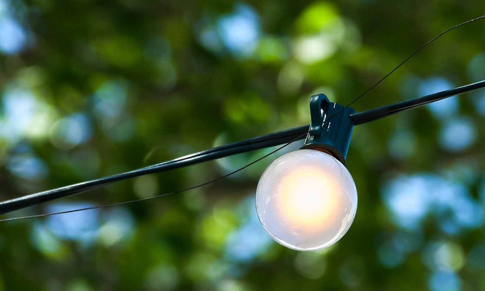 Illuminated light bulb glowing warm white outdoors