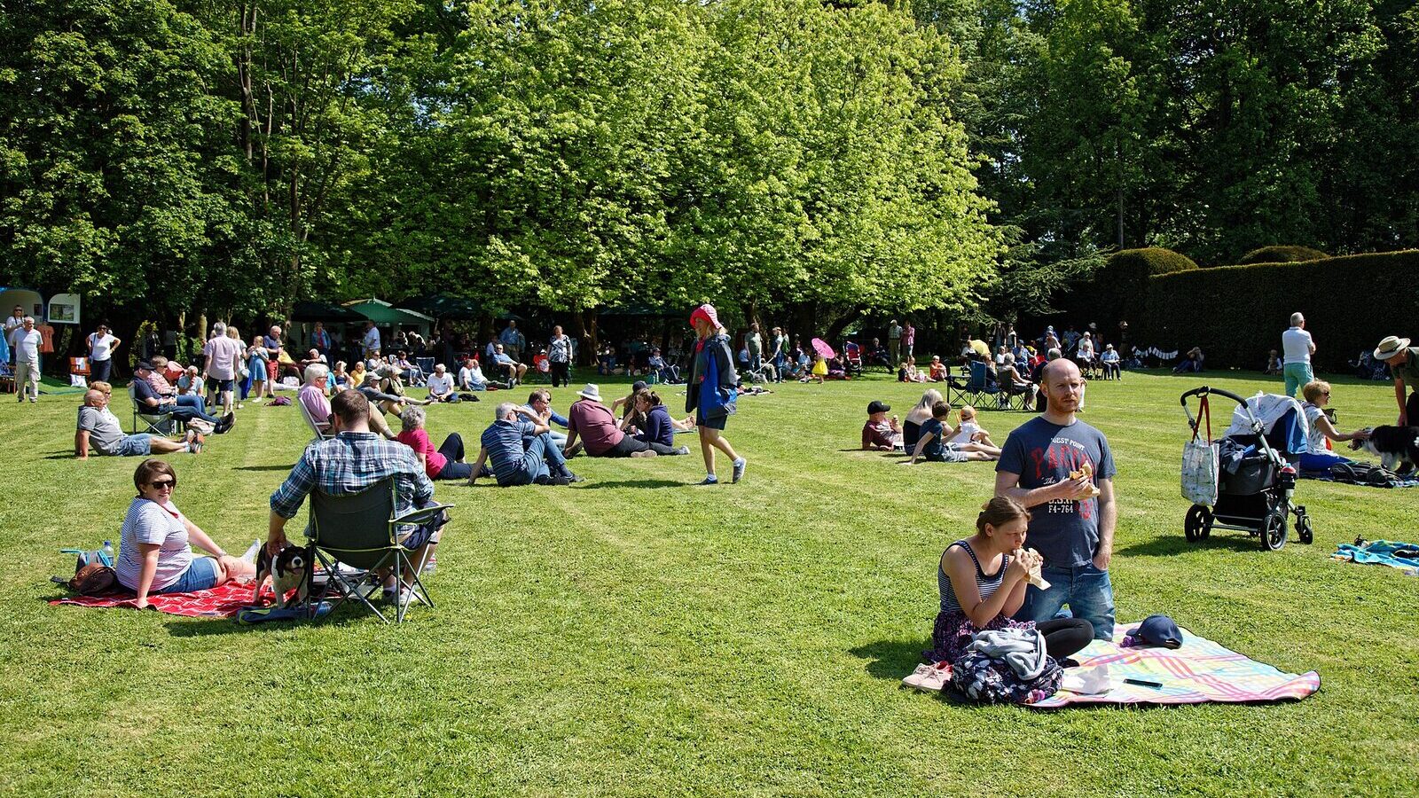 People sitting beside a freshly mown garden lawn