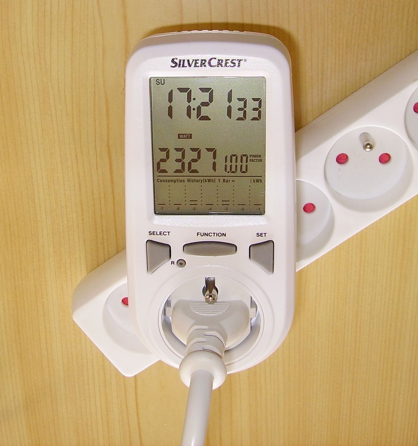 Plug-in power and energy monitor showing consumption in a wall socket