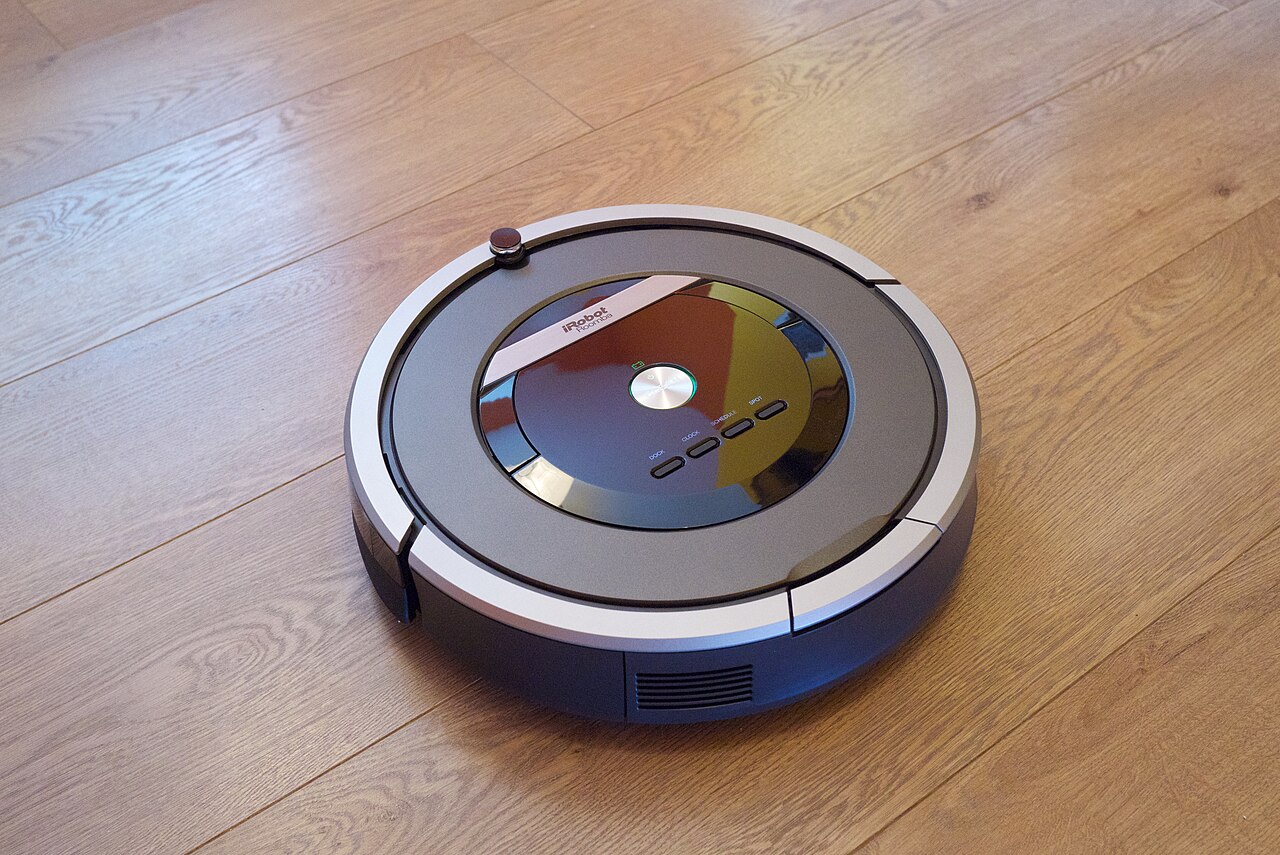 iRobot Roomba robot vacuum cleaning a laminate wood floor