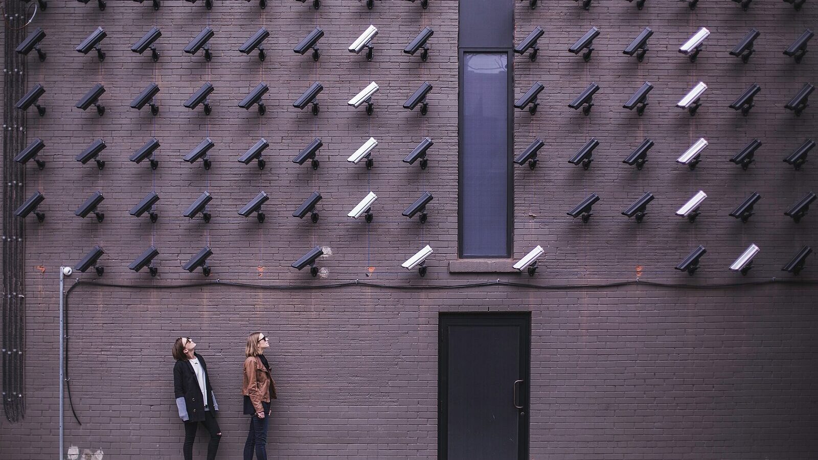 CCTV security cameras mounted on a wall above a street