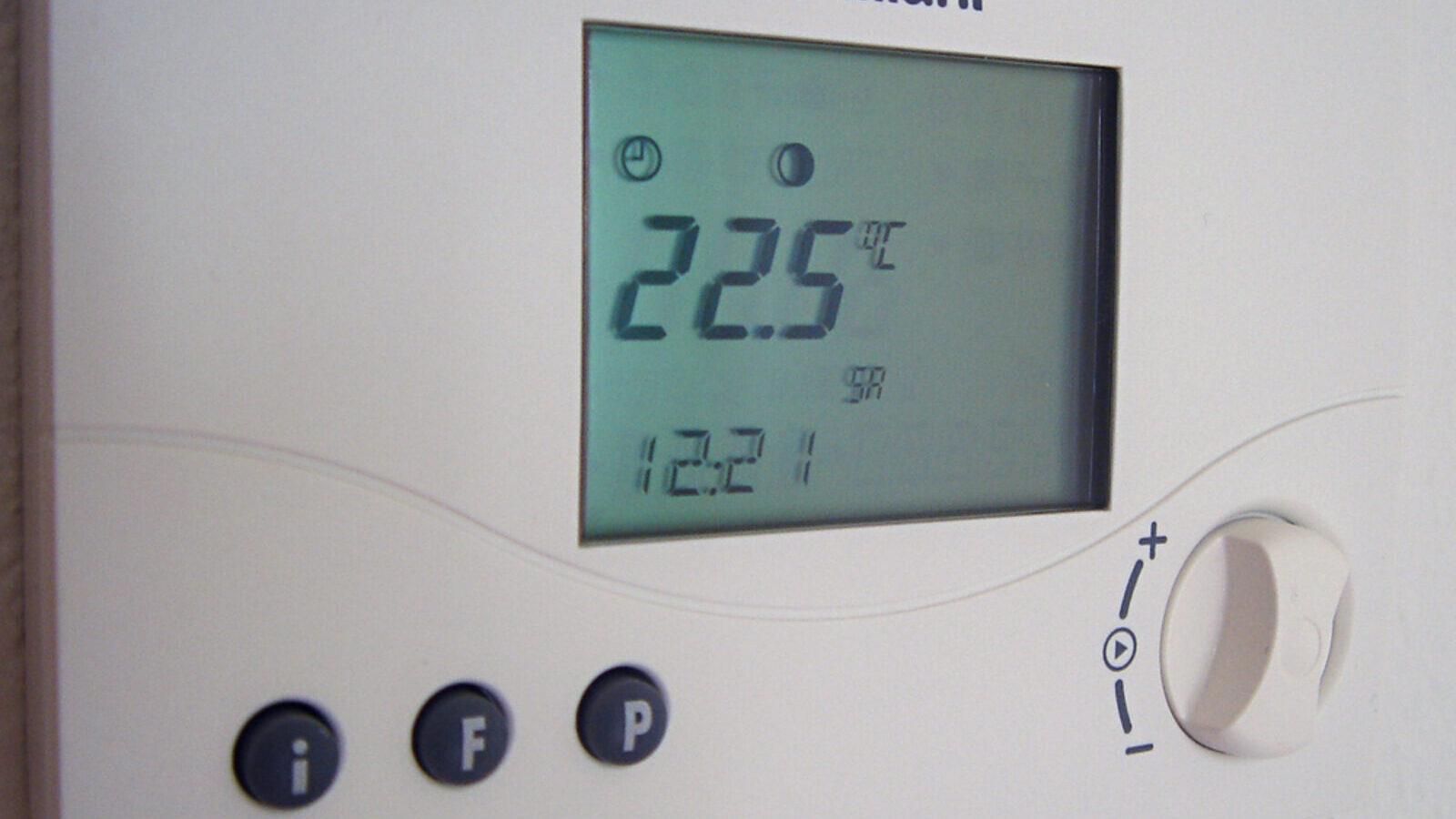 Round wall-mounted room thermostat in a home