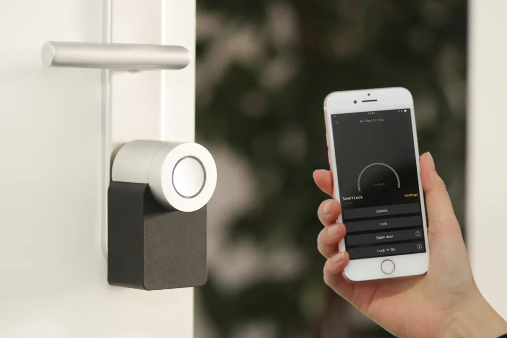 Nuki Smart Lock fitted to a door, controlled via iPhone